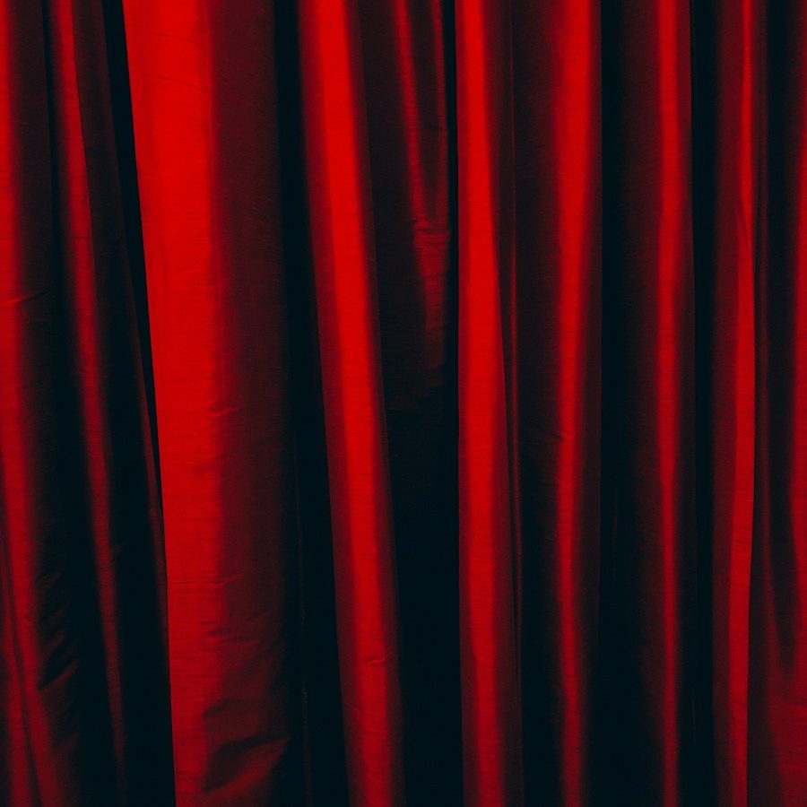 a close up of a red curtain with a black background